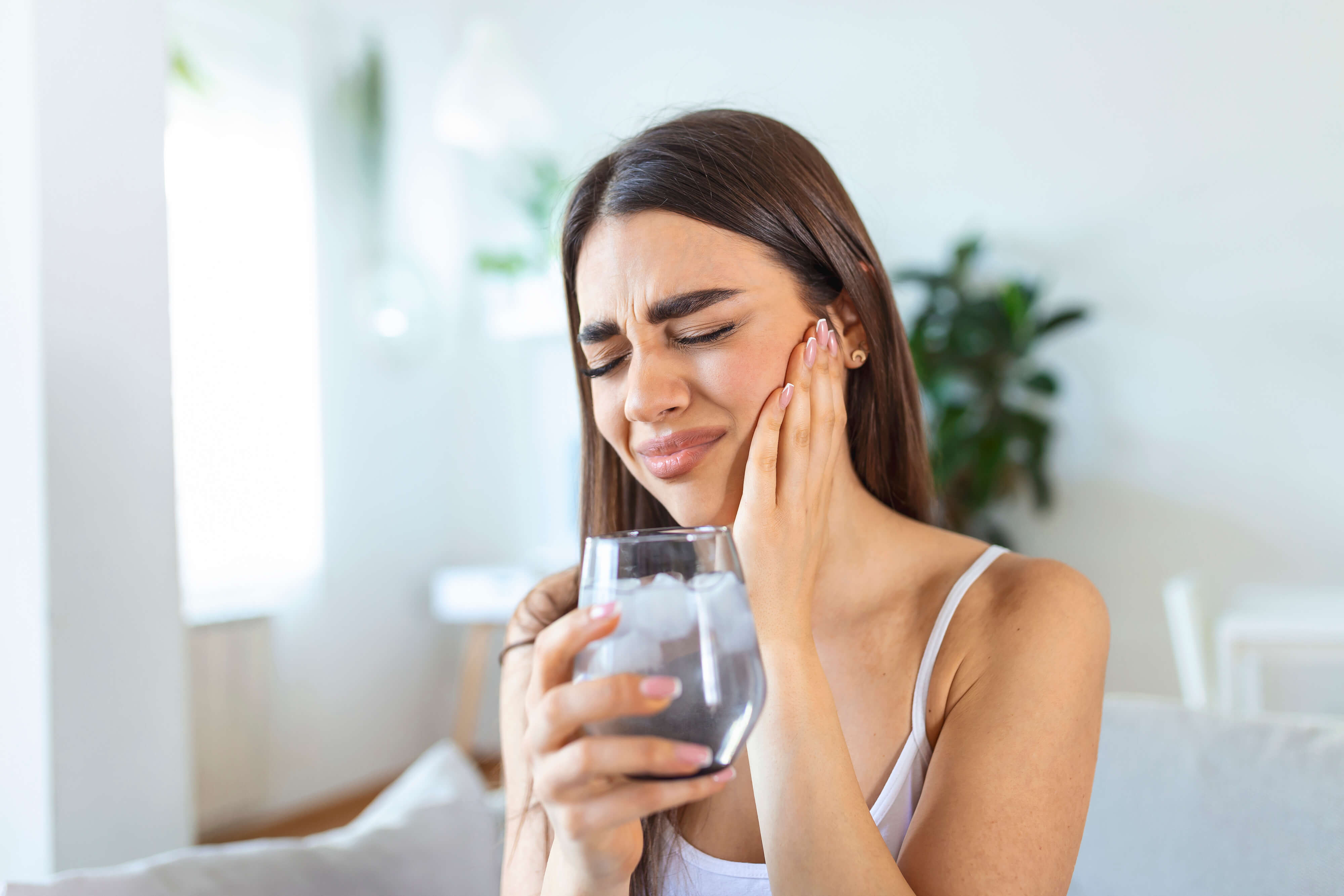 Woman with sensitive teeth after drinking cold water.